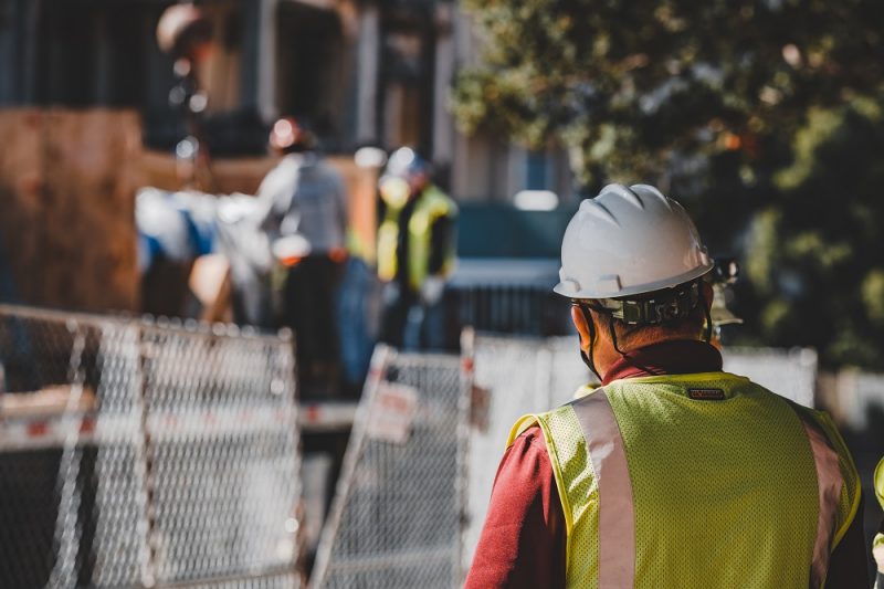 Construction employee wearing yellow vest and hard hat